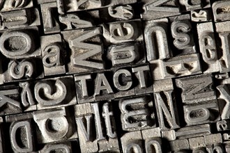 Old lead letters forming the word TACT