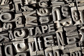 Old lead letters forming the word TAPE