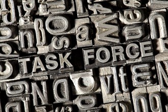 Old lead letters forming the term TASK FORCE