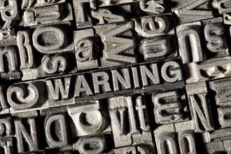 Old lead letters forming the word WARNING