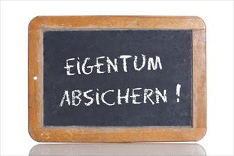 Old school blackboard with the words EIGENTUM ABSICHERN!