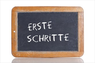 Old school blackboard with the term ERSTE SCHRITTE