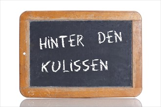 Old school blackboard with the term HINTER DEN KULISSEN