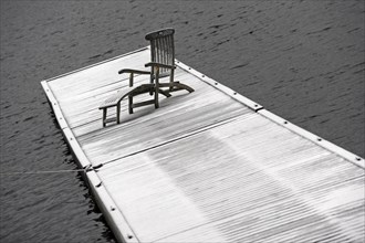Deck chair on snow-covered jetty at Spitzingsee Lake