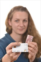 Woman holding a health insurance card and a 10 euro banknote