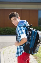 Boy carrying a school bag on the way to school