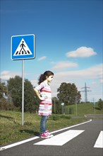 Girl waiting at a zebra crossing