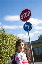 Girl standing beside a stop sign