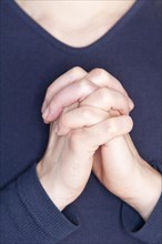 Woman praying with her hands clasped