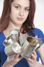 Young woman recycling tin cans