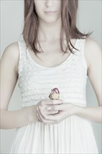 Young woman holding a rose in her hands