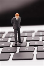 Figurine of businessman standing on a laptop