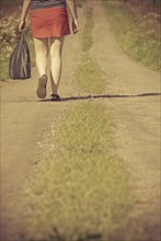 Woman walking on a dirt road