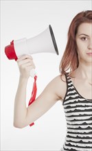 Young female holding a megaphone by her ear