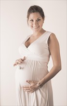 Pregnant woman holding hand with miniature disco ball on her stomach