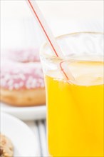 Glass of orange soda with drinking straw