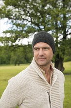 Man wearing a beanie standing in a park