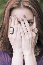 Young woman covering her face with her hands