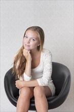Young woman sitting in a vintage chair