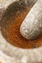 Fresh cinnamon being ground in a marble mortar