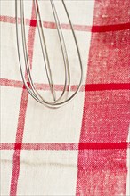 Stainless whisk on tea-towel