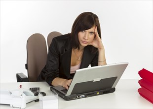 Young woman with a laptop sitting at a desk