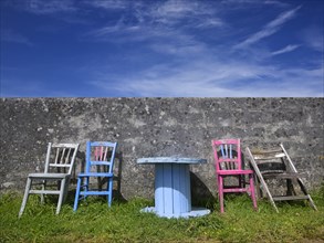Colourful group of seats against a wall with an old cable drum as a table