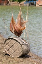 Fish trap made of bamboo and a fishing net on the Sangkae river