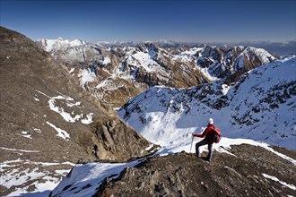 Mountain climber on the summit ridge while descending from Wilde Kreuzspitze Mountain in the Pfunderer Mountains