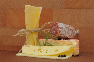 Various types of cheeses and a piece of salami