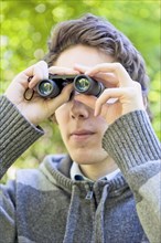 Young man looking through binoculars