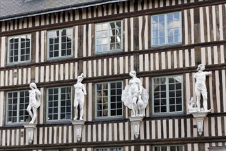 Norman half-timbered house with decorative figures on the facade