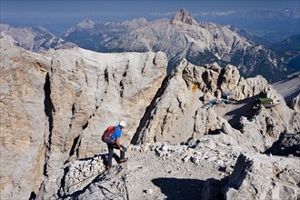 Mountaineer climbing the Via Ferrata Marino Bianchi climbing route on Monte Cristallo to the summit of Cristallino di Mezzo above Cortina
