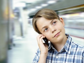 Teenager using a mobile phone in an underground railway station
