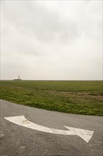 White directional arrow on a road near Westerhever lighthouse
