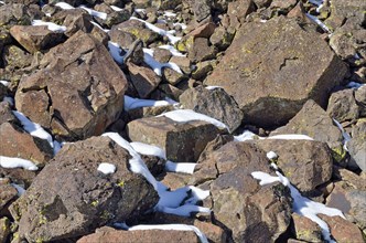 Fallen basalt rocks with remnants of snow