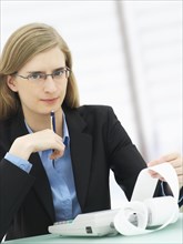 Businesswoman wearing glasses and using a calculator