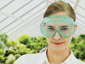 Scientist wearing a protective mask in a greenhouse