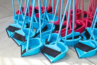 Blue and red brooms with shovels