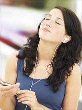 Young woman listening to music at a subway station
