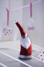 Christmas ambience with a felt Santa Claus and Christmas tree ornaments made of glass