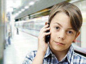 Teenager using a mobile phone in an underground railway station