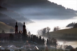 The abbey church of St. Peter at atmospheric inversion in autumn
