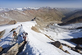 Hikers on the summit ridge ascending to Similaun on Niederjochferner Mountain in Val Senales valley