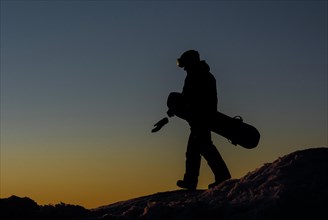 Snowboarder on an ice hill on the Fichtelberg at sunset