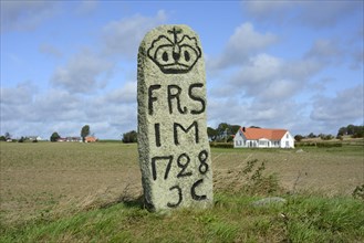 Old milestone on a country road in Scania