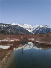 Snow-covered Japanese Alps reflected in Lake Taisho Pond