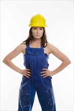 Woman wearing blue overalls and a hardhat