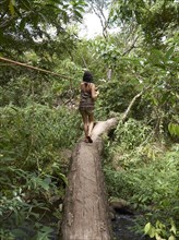 Woman balancing on a tree trunk