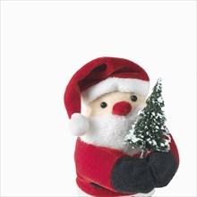 Santa Claus doll holding a Christmas tree